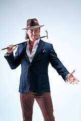 Image showing The mature man in a suit and hat holding cane.