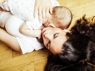 Image showing young brunette happy mother holding toddler baby son, breast-feeding concept, lifestyle modern people