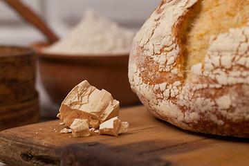 Image showing Homemade bread on old cutting board with a pile of fresh yeast