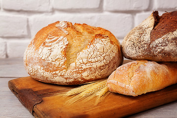 Image showing Fresh homemade bread assortment on old cutting board