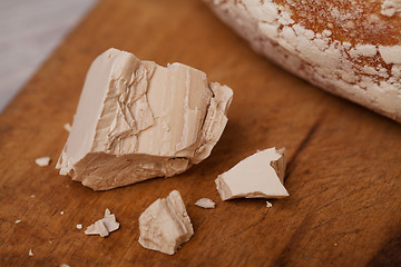 Image showing A pile of fresh yeast with a Homemade bread on old cutting board
