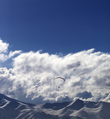 Image showing Winter mountain in evening and sunlight silhouette of parachutis