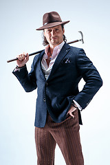 Image showing The mature man in a suit and hat holding cane.