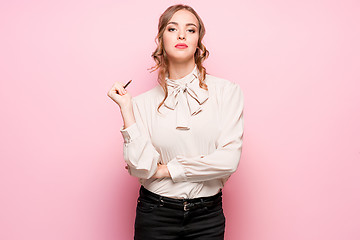 Image showing The serious frustrated young beautiful business woman on pink background