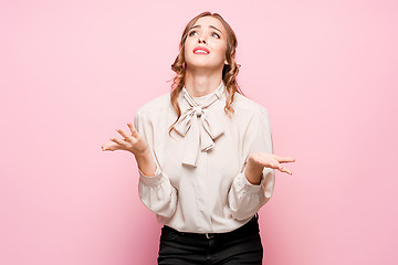 Image showing The serious frustrated young beautiful business woman on pink background