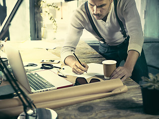 Image showing Architect working on drawing table in office