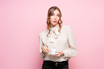 Image showing The serious frustrated young beautiful business woman on pink background