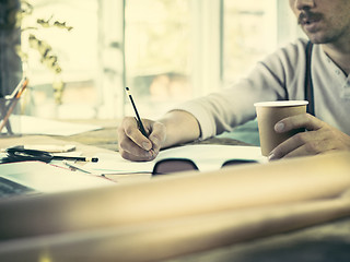 Image showing Architect working on drawing table in office