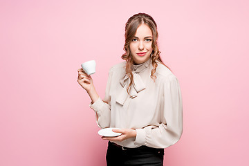 Image showing The serious frustrated young beautiful business woman on pink background