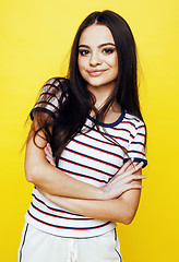 Image showing lifestyle people concept: pretty young school teenage girl having fun happy smiling on yellow background closeup