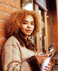 Image showing young pretty african american women drinking coffee outside in c