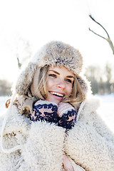 Image showing young pretty teenage hipster girl outdoor in winter snow park having fun drinking coffee, warming up happy smiling, lifestyle people concept