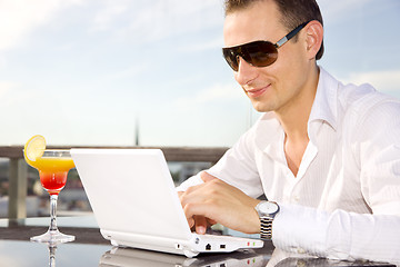 Image showing businessman on leisure with laptop and cocktail