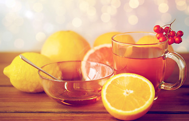 Image showing tea with honey, lemon and rowanberry on wood