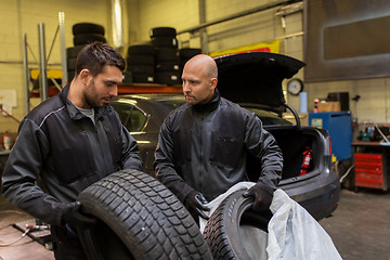 Image showing auto mechanics changing car tires at workshop