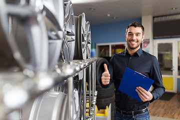 Image showing auto business owner and wheel rims at car service