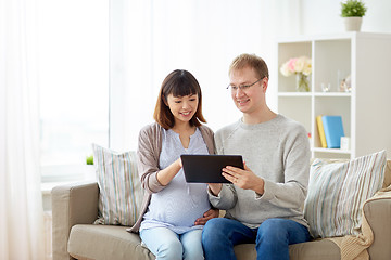 Image showing husband and pregnant wife with tablet pc at home