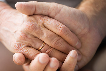 Image showing close up of senior couple holding hands