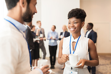 Image showing business people with conference badges and coffee