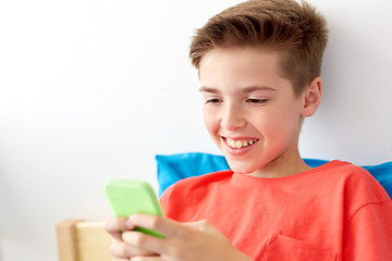 Image showing happy smiling boy with smartphone at home