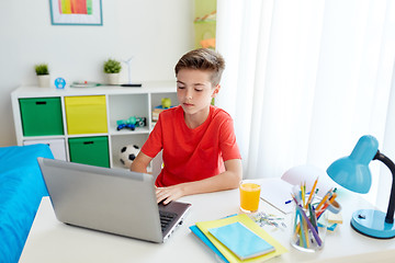 Image showing student boy typing on laptop computer at home