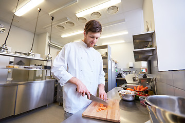 Image showing happy male chef cooking food at restaurant kitchen