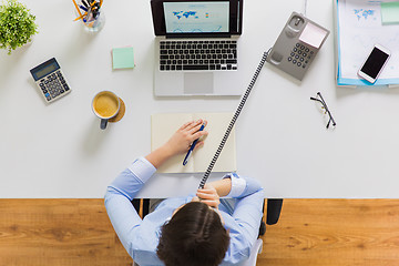 Image showing businesswoman calling on phone at office table