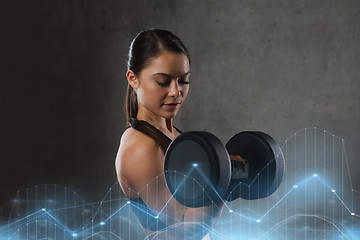 Image showing young woman flexing muscles with dumbbells in gym