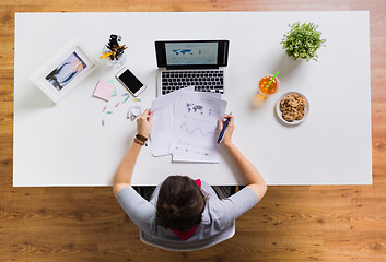 Image showing woman with laptop and papers at office table