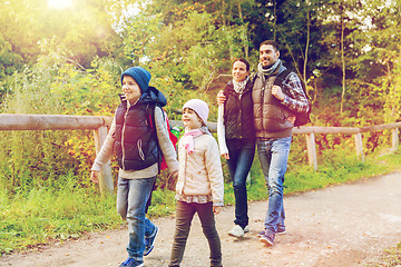 Image showing happy family with backpacks hiking in woods