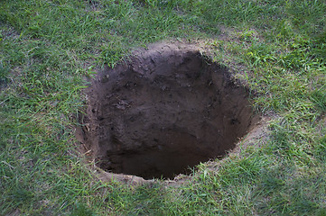 Image showing Deep dirt hole in ground or lawn