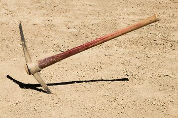 Image showing Pick Ax plunged into dirt ground