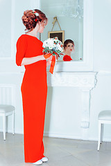 Image showing Woman In Red Against A Mirror