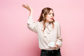 Image showing The serious frustrated young beautiful business woman on pink background