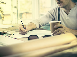 Image showing Architect working on drawing table in office