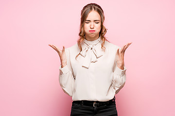 Image showing The serious frustrated young beautiful business woman on pink background