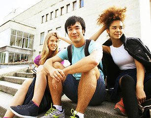 Image showing cute group of teenages at the building of university with books 