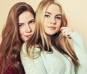 Image showing Two young girlfriends in winter sweaters indoors having fun. Lif