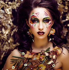 Image showing beauty woman with face art and jewelry from flowers orchids clos