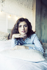 Image showing young pretty brunette woman in her bedroom sitting at window, happy smiling lifestyle people concept 