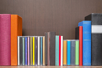 Image showing stack of colorful books, cd and cassettes in the bookself