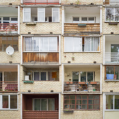 Image showing Old building with balconies full of flowers, tables, chairs