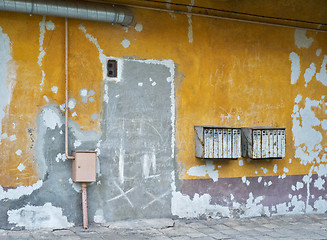 Image showing Rusty mailboxes on cracked stucco wall