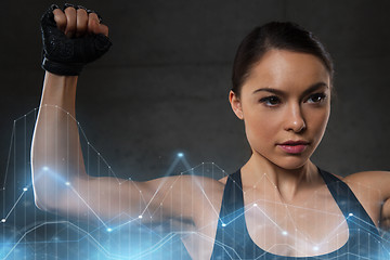 Image showing young woman flexing muscles in gym