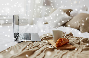 Image showing laptop, coffee and croissant on bed at cozy home