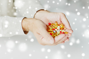 Image showing close up of senior man hands holding pills