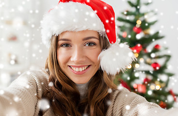 Image showing woman in santa hat taking selfie at christmas