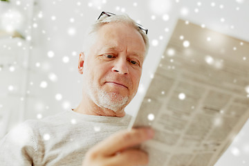 Image showing close up of senior man reading newspaper at home