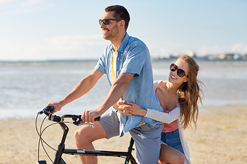 Image showing happy young couple riding bicycle on beach 