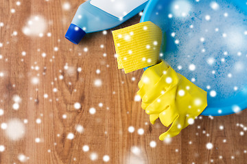 Image showing basin with cleaning stuff on wooden background